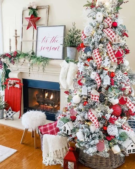 Snowy living room flocked tree with black gingham ribbon, stone fireplace, warm amber lighting