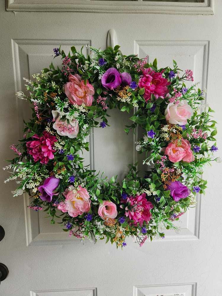 Modern colorful entry door featuring jewel-toned pink and purple floral Christmas wreath.