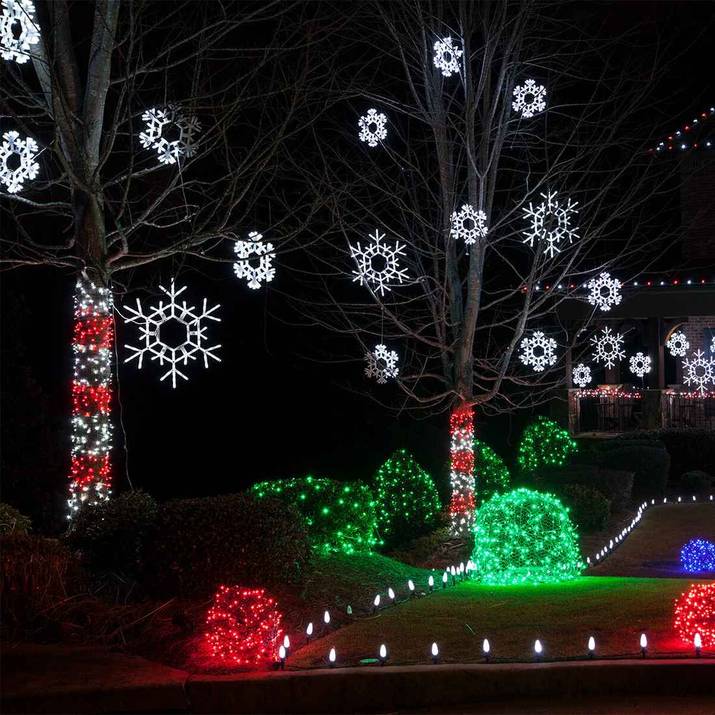 Oversized folding snowflake outdoor christmas decorations attached to front wall or porch.