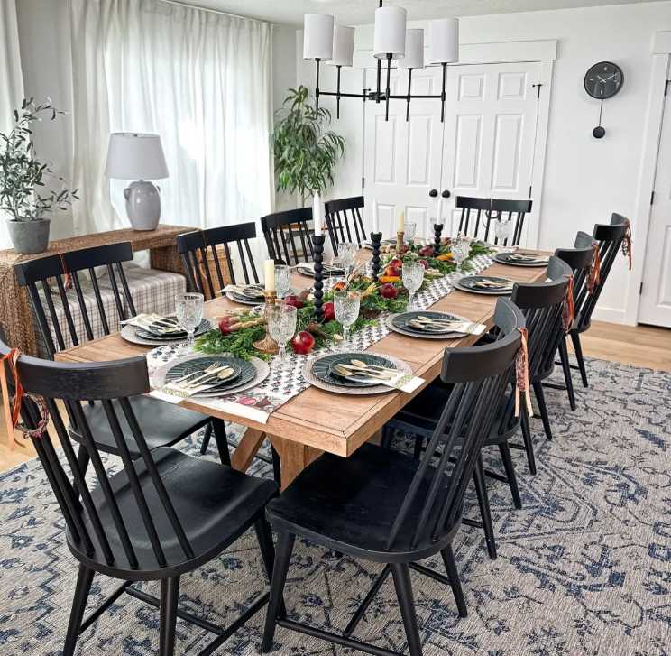 Rustic kitchen, folk‑style runner, bright red apples, black metal chairs, natural wood table