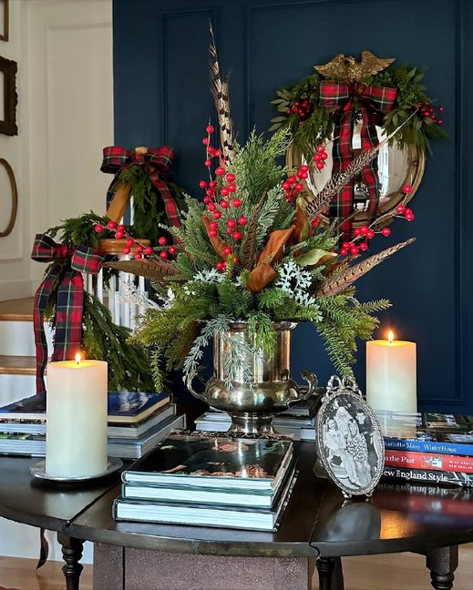 Coffee table with mixed evergreen garland, silver baubles, ivory candles, warm ambient lighting.