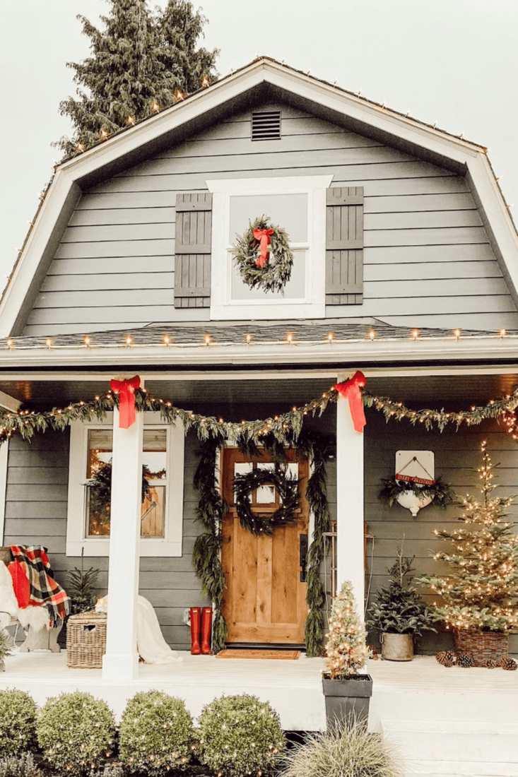 A neutral-toned porch with simple outdoor christmas decorations and cozy textures.