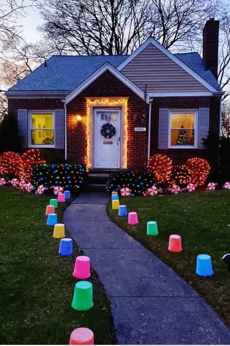 A traditional porch with classic red and green outdoor christmas decorations and plaid patterns.
