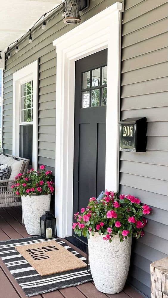 Front porch with terracotta tiles, woven kilim rug, and cactus planters