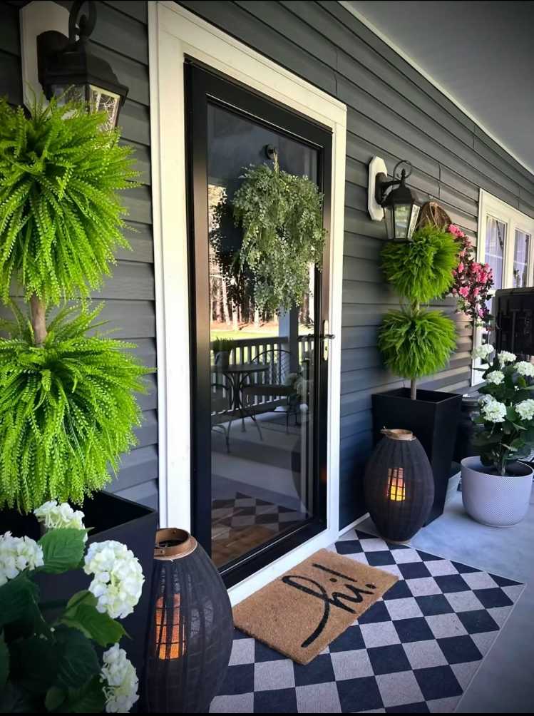 Front porch with light gray bench, white sheepskin throw, and simple pine planters