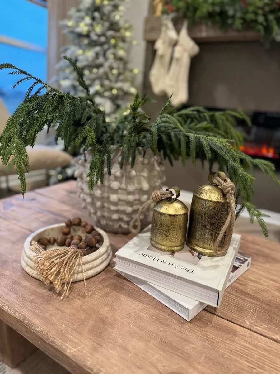 Frosted glass candles with fir tree labels on a tray with winter greenery.