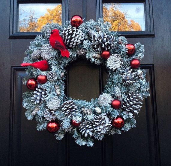 Snowy winter front porch with frosted pinecone wreath featuring a bright red cardinal figure.