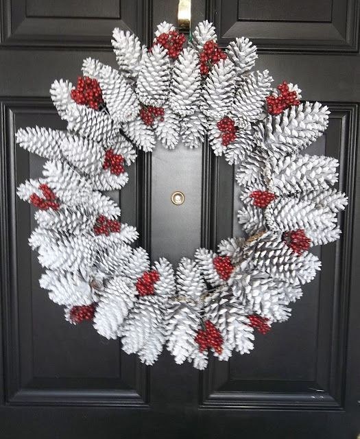 Traditional winter doorway displaying frosted pinecone wreath laden with clusters of red berries.