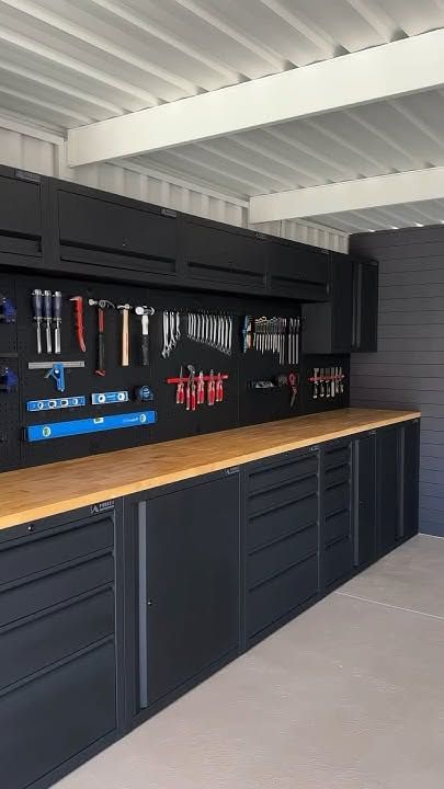 garage with glossy black tool cabinets, walnut shelving, cool LED strip lighting, organized tools
