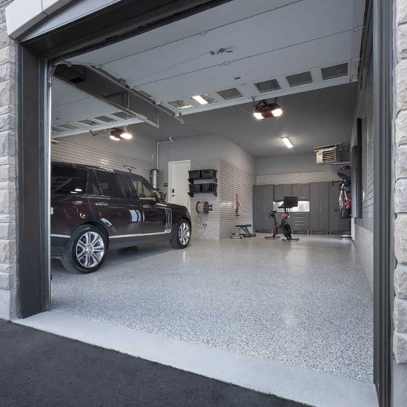 garage split into car parking and home gym, rubber flooring, charcoal walls, natural light