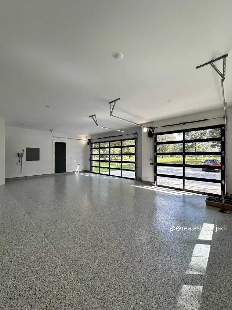 garage with floor‑to‑ceiling glass doors, sleek black frames, steel shelving, bright daylight