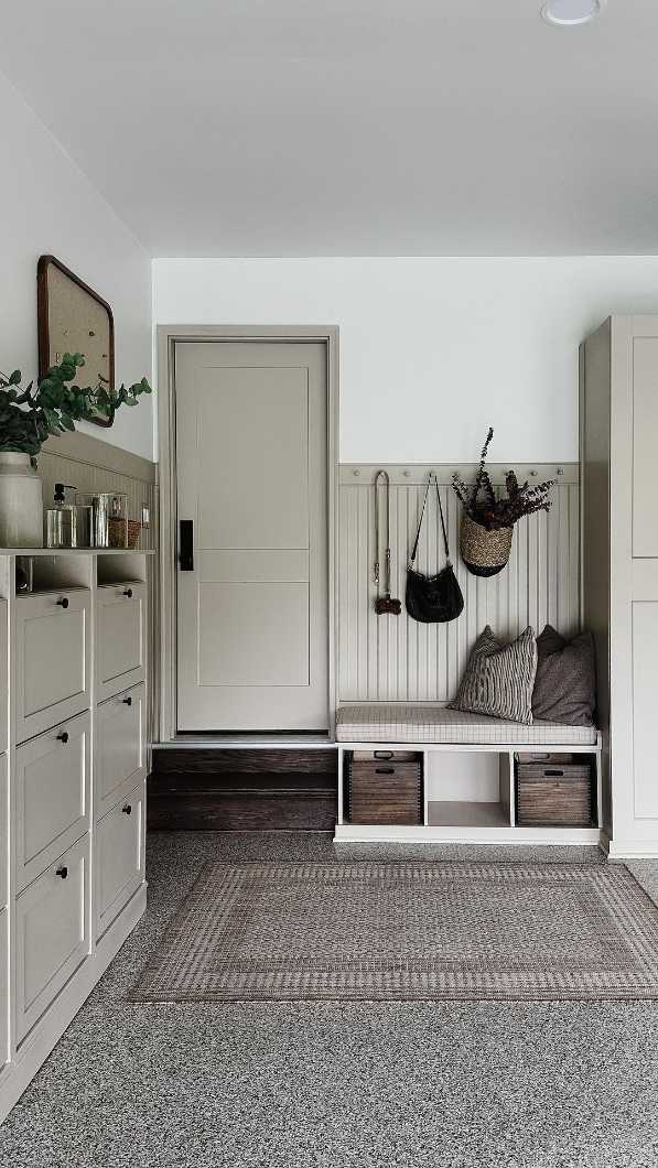 garage nook with tilt‑out shoe cabinet, soft gray finish, recessed lighting, natural wood floor