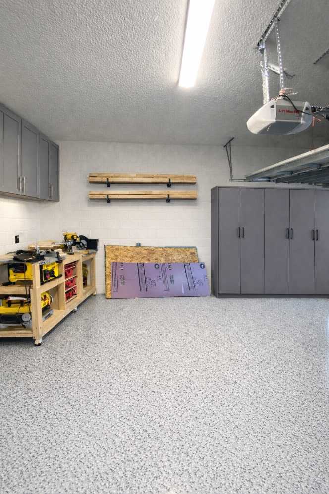 garage with tall lumber rack, steel frame, reclaimed wood planks, bright daylight, organized tools