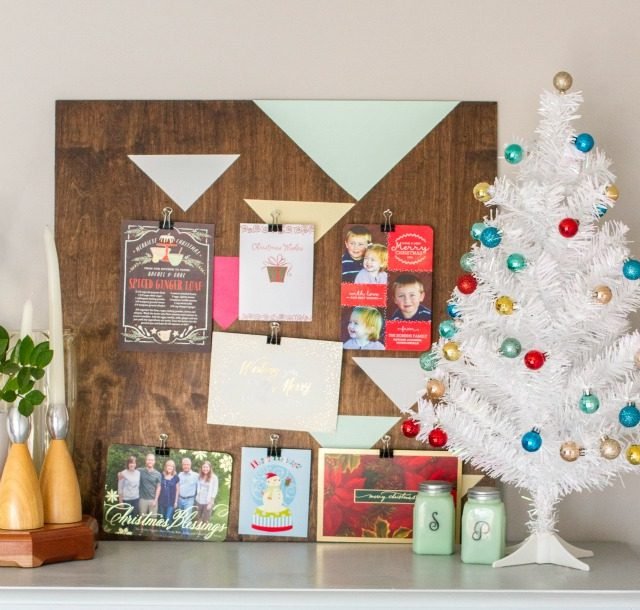 Contemporary brass wire geometric grid on plaster wall adorned with festive greeting cards