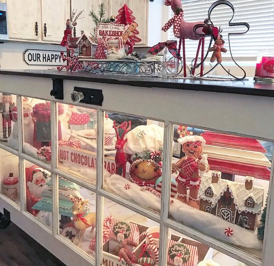 Miniature gingerbread bakeshop display on the kitchen bar with tiny cookies.