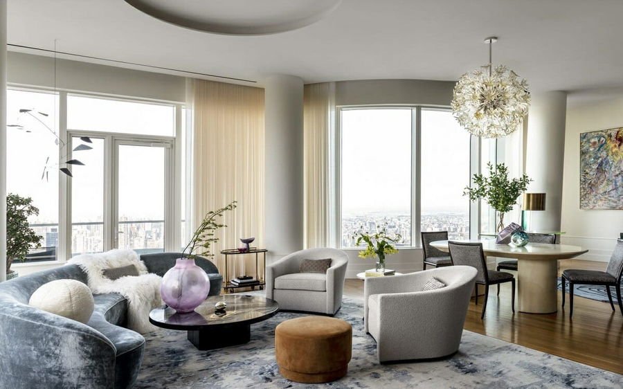 Coral patterned rug, glass coffee table, white sofa, and bright living room light.