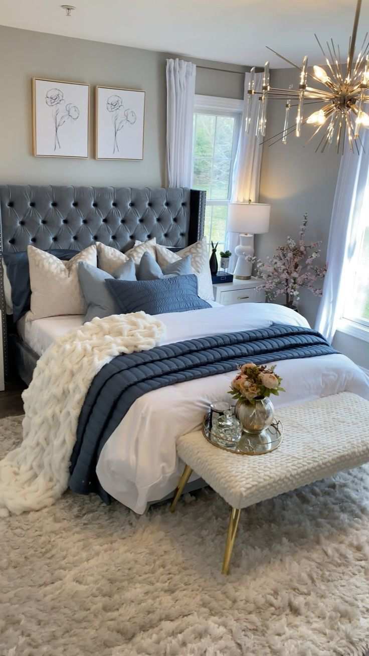 Glam master bedroom with a grey tufted headboard and vibrant blue accents