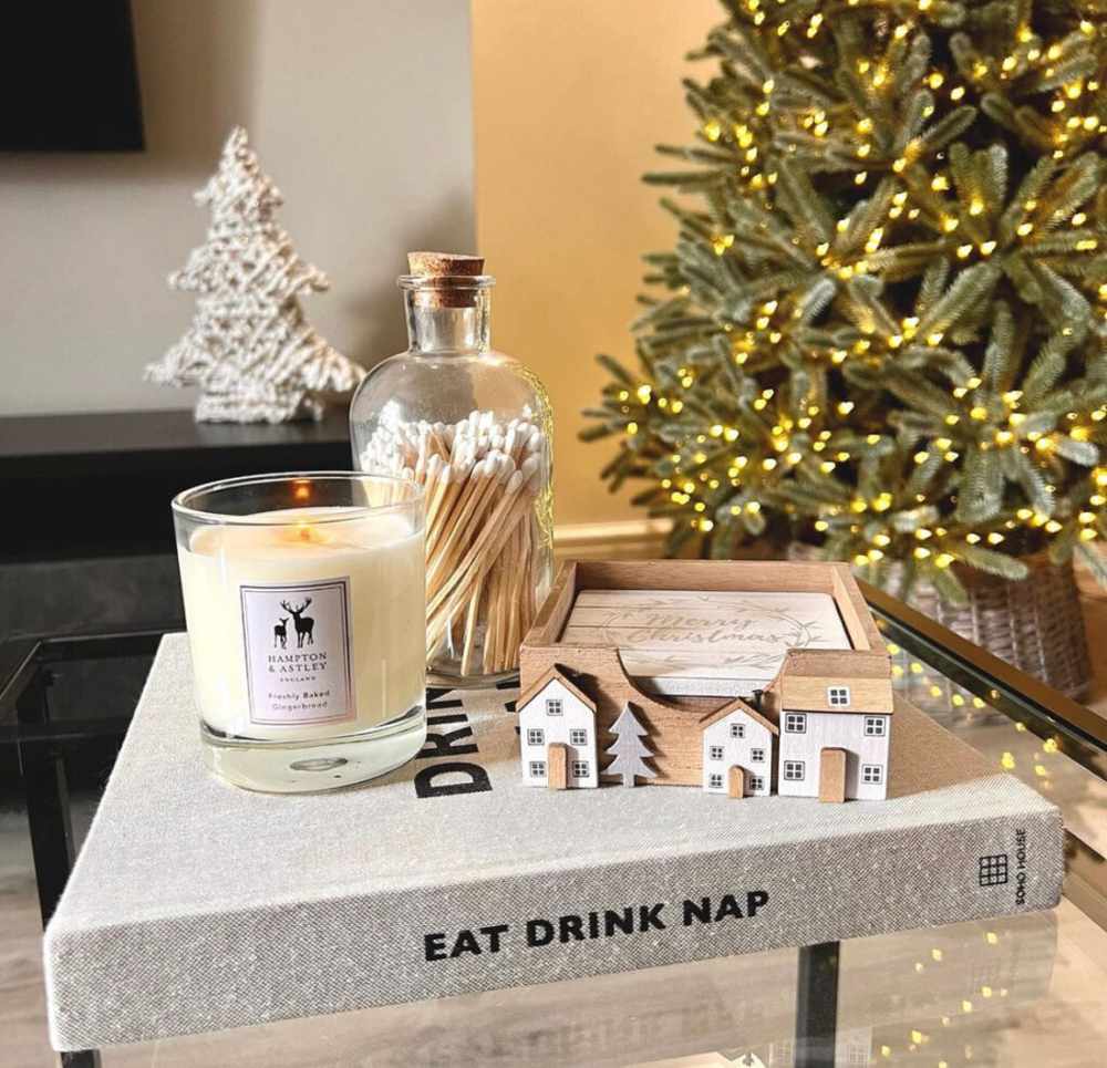 Decorative glass jar holding long matches next to a single elegant candle.