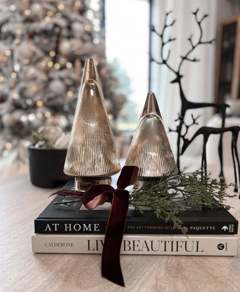 Clear glass mini trees placed on top of a stack of vintage books.