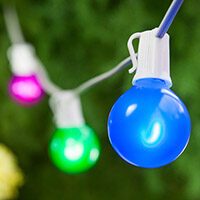 Backyard patio or lawn with overhead globe string lights as outdoor christmas decorations.