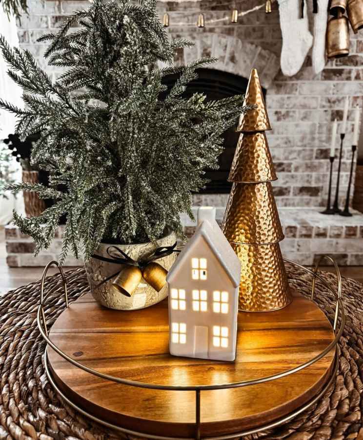 Ceramic house luminaries on a tray surrounded by small greenery and ornaments.