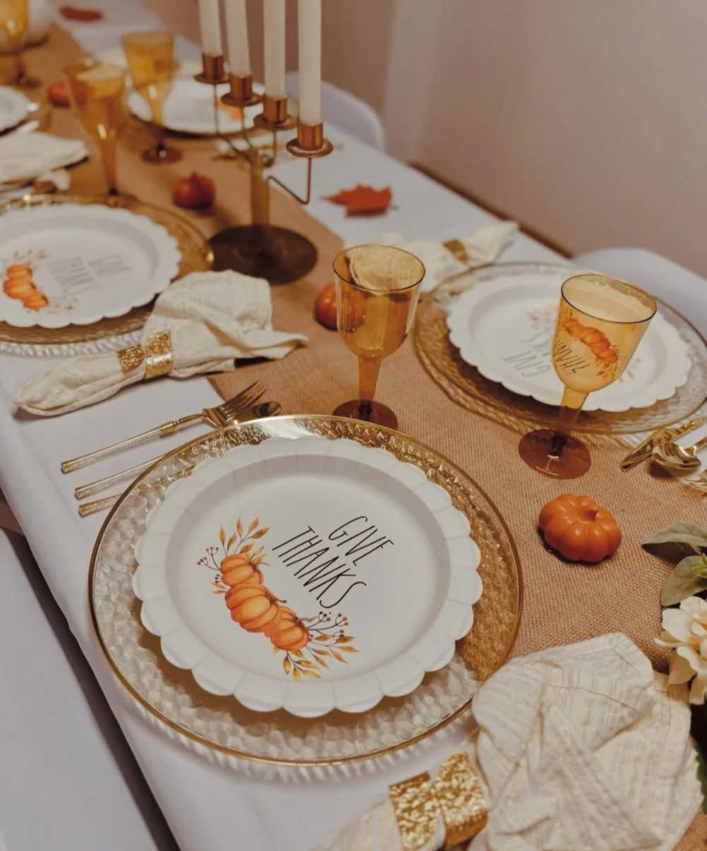Formal banquet, gold foil place cards, amber glass vases, deep mahogany table, soft candlelight