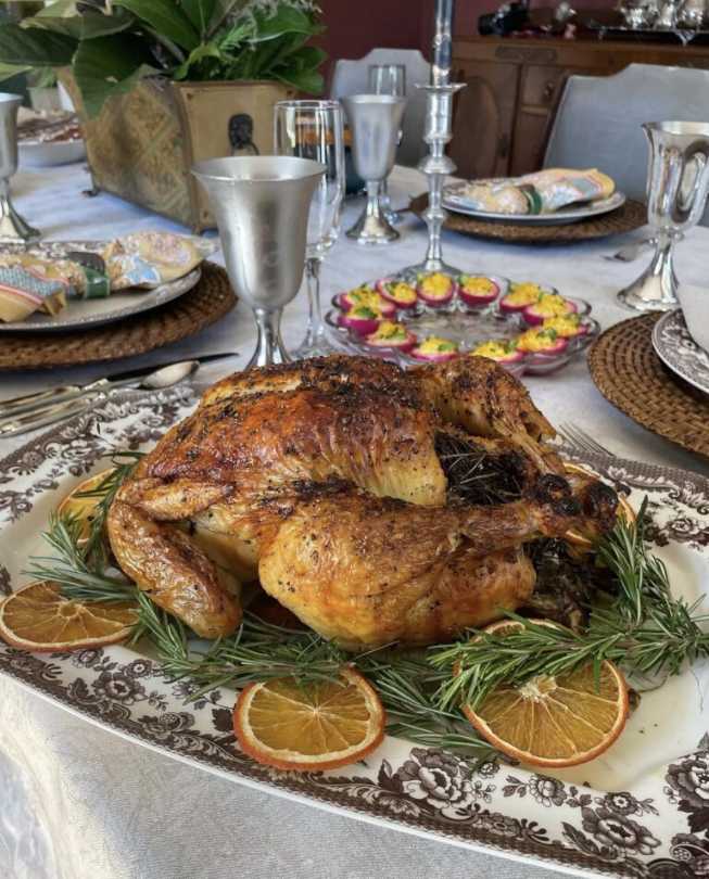 Large roasted turkey on herb platter, golden glaze, rosemary sprigs, soft natural lighting, wooden board
