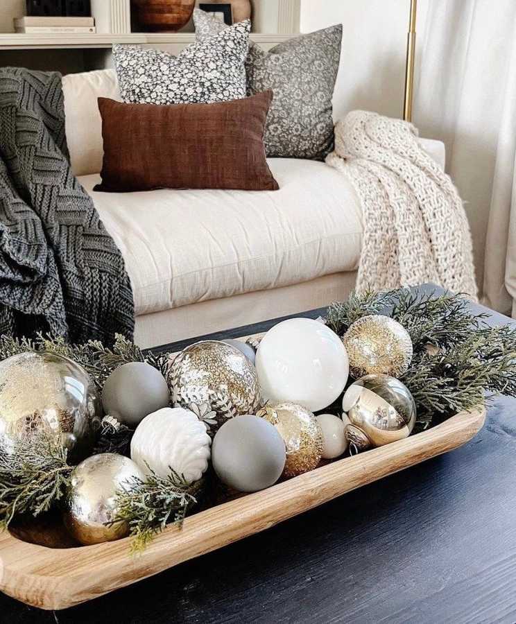 Warm Christmas coffee table decor displaying rich green foliage and champagne gold holiday accessories.