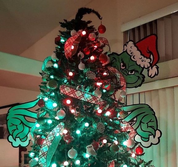 Close up of a Grinch face and hands in a cozy room