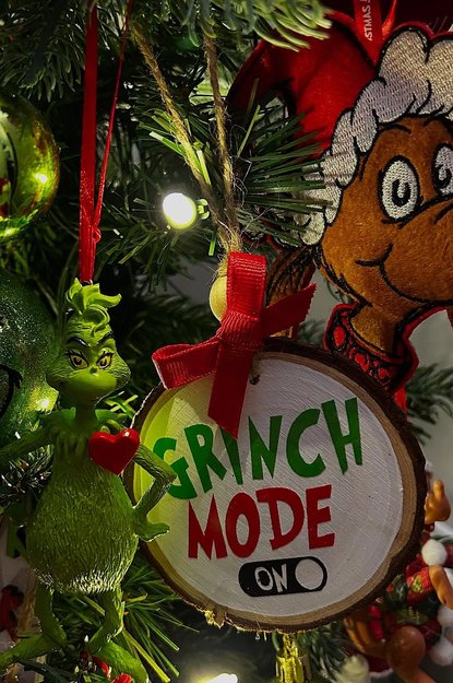 Tree with a Grinch Mode On button ornament and green lights