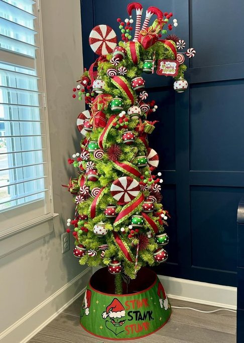Tree with green ribbed ornaments in a bright room