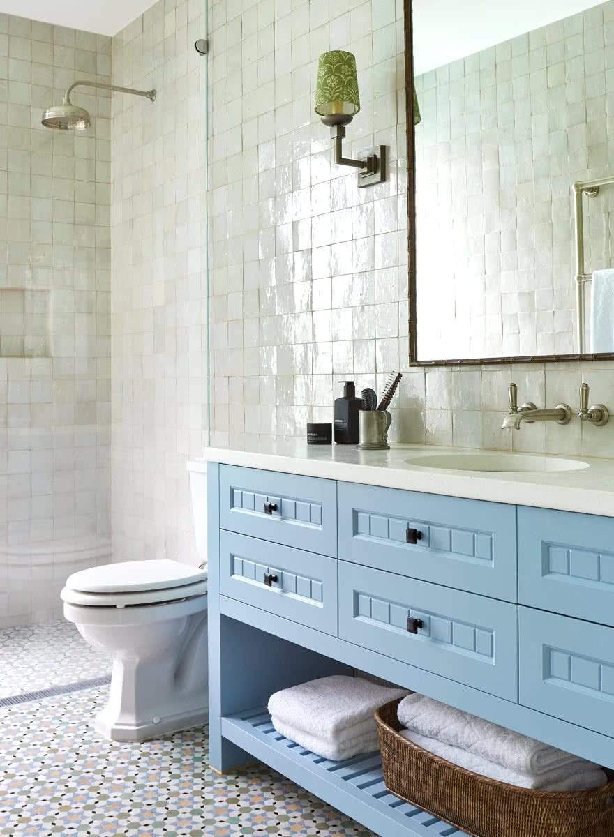 Guest bathroom with soft light blue vanity, white subway tile backsplash, quartz counter, and warm vanity lights.