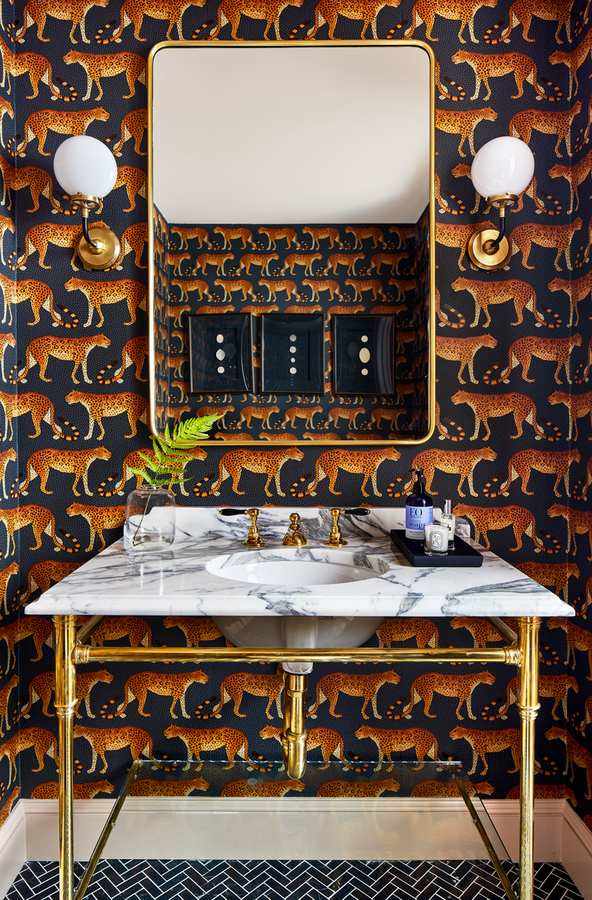 A daring guest bathroom with bold tiger print wallpaper and sleek marble vanity tops.