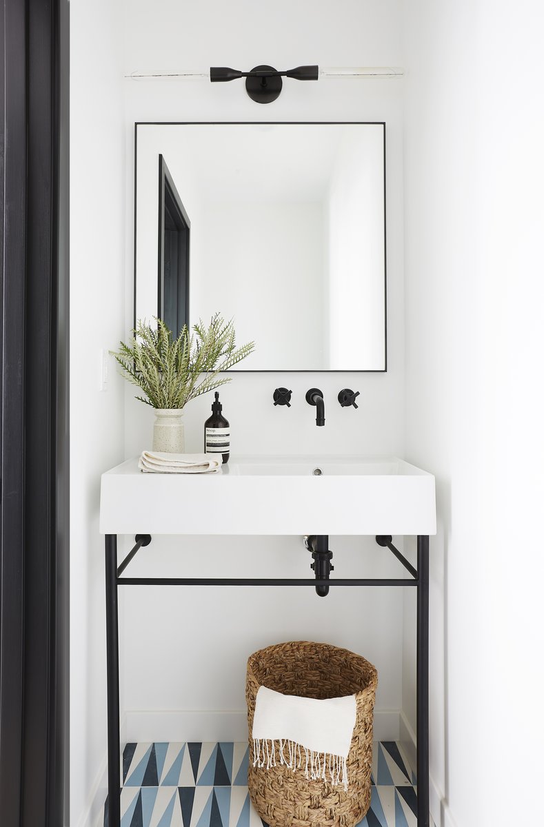 Bright guest bathroom featuring a traditional white console sink and polished nickel hardware.