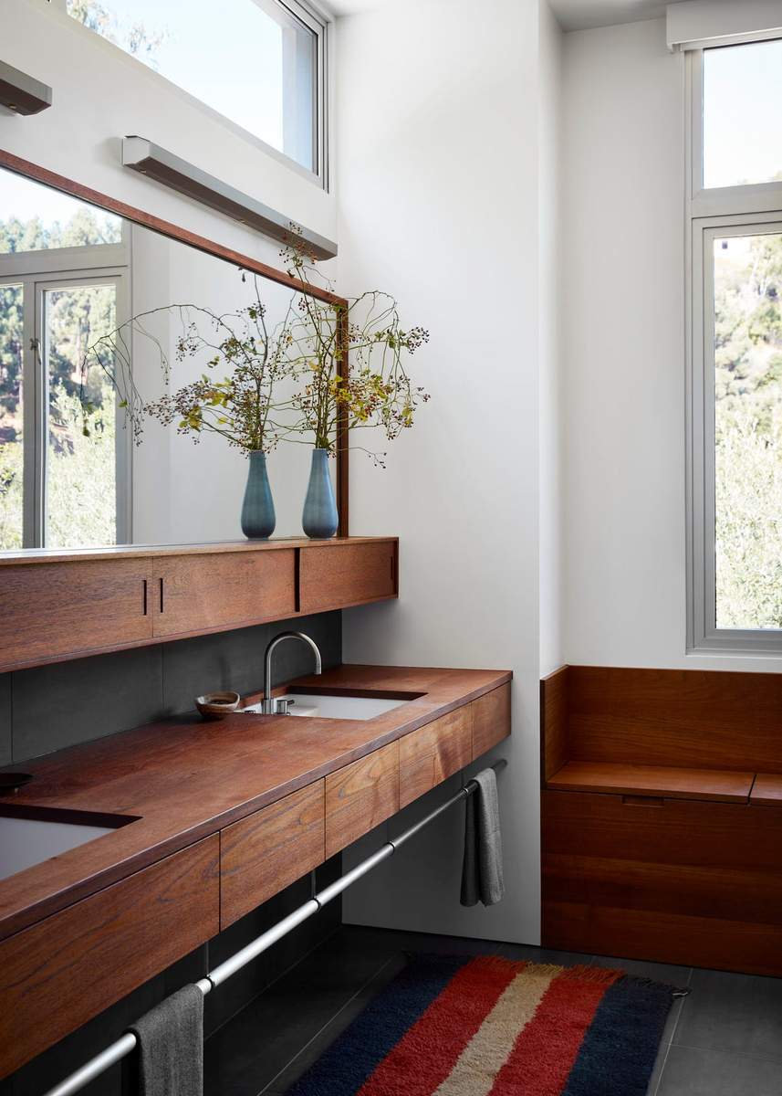 Modern guest bathroom with a wood double vanity and a full-length wall mirror.