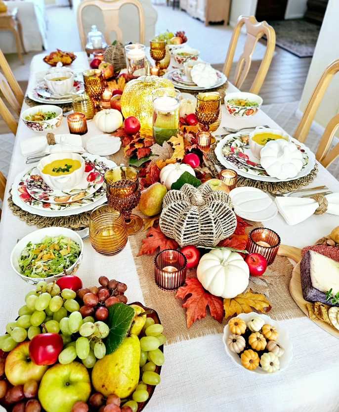 Rustic banquet table, overflowing harvest centerpiece, burlap runner, cornucopia, warm candlelight