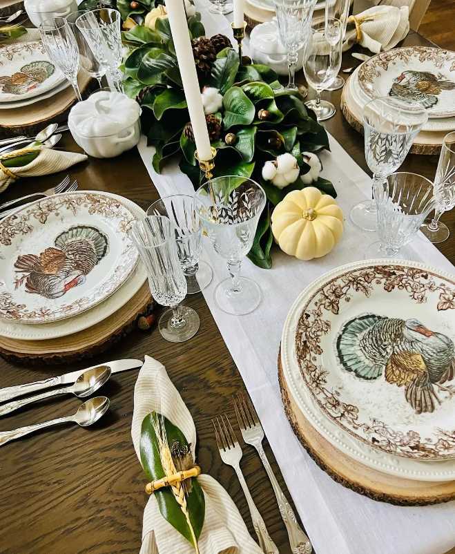 Elegant dining, heritage turkey dinnerware, magnolia leaf garland, ivory table runner, cool white lighting