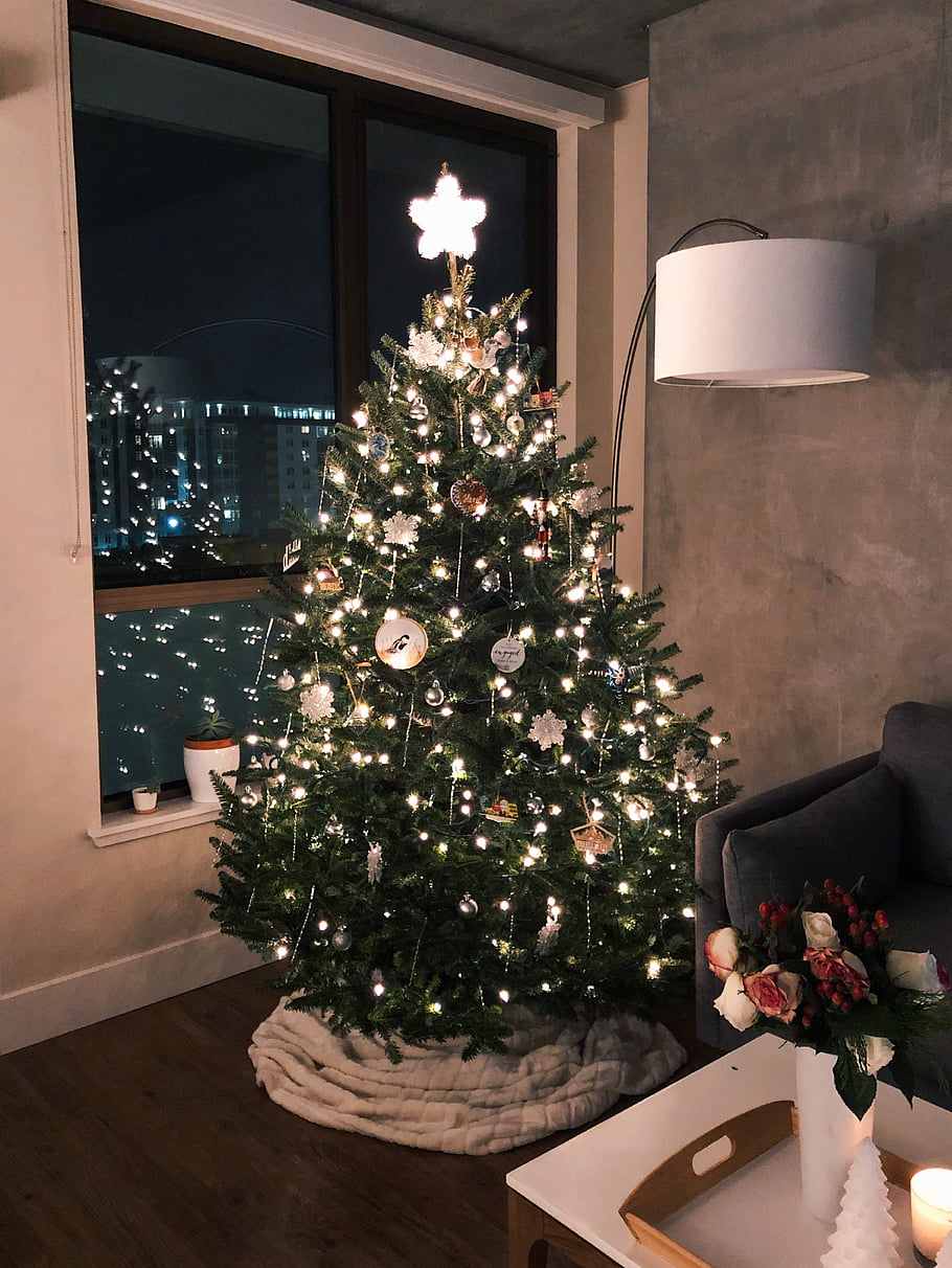 Luxuriously lit Christmas tree with layered warm lights velvet ribbon and brass ornaments