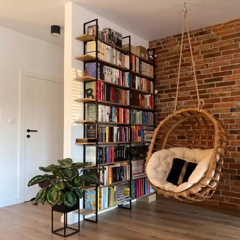 Industrial home library corner with exposed brick walls and a cozy hanging swing chair.