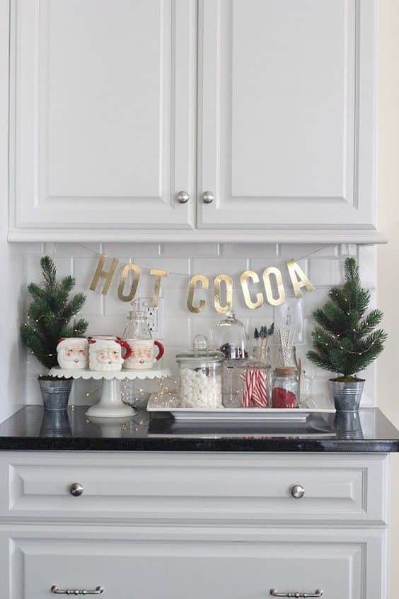 DIY bunting banner reading Hot Cocoa hung above the counter with mugs below.