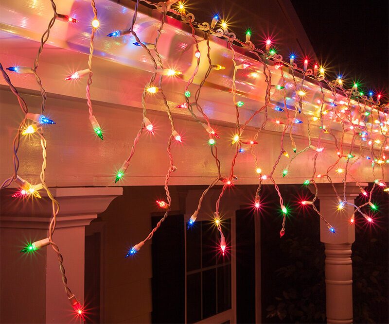 House roofline decorated with classic, cascading icicle-style outdoor christmas decorations.