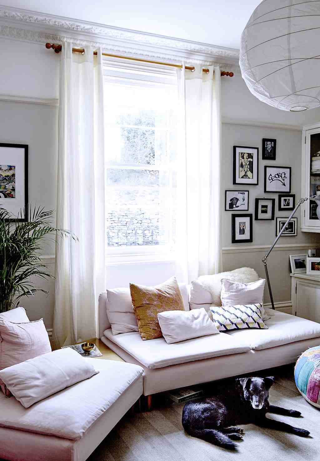 Luxurious small living room with rich velvet corner sectional, framed mirror, warm lighting.