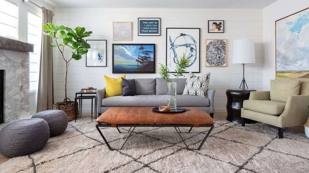 Small bright living room with nested marble top coffee tables and cream plush rug.
