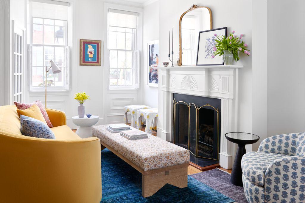 Monochromatic beige living room with layered jute rug, woven pouf, warm ambient lighting.