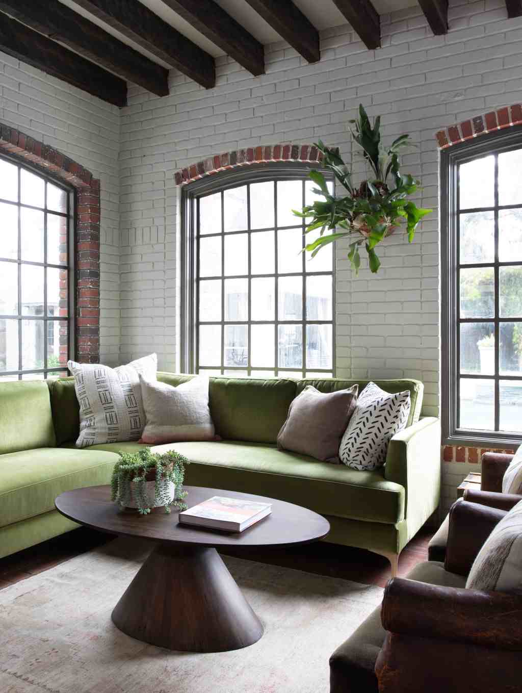 Functional small living room with plush storage ottoman coffee table and decorative wooden tray.