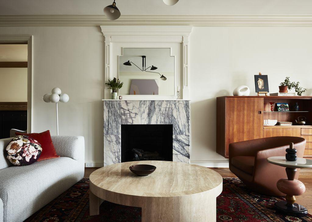 Small living room with custom sage green built-in bookshelves framing a neutral linen sofa.