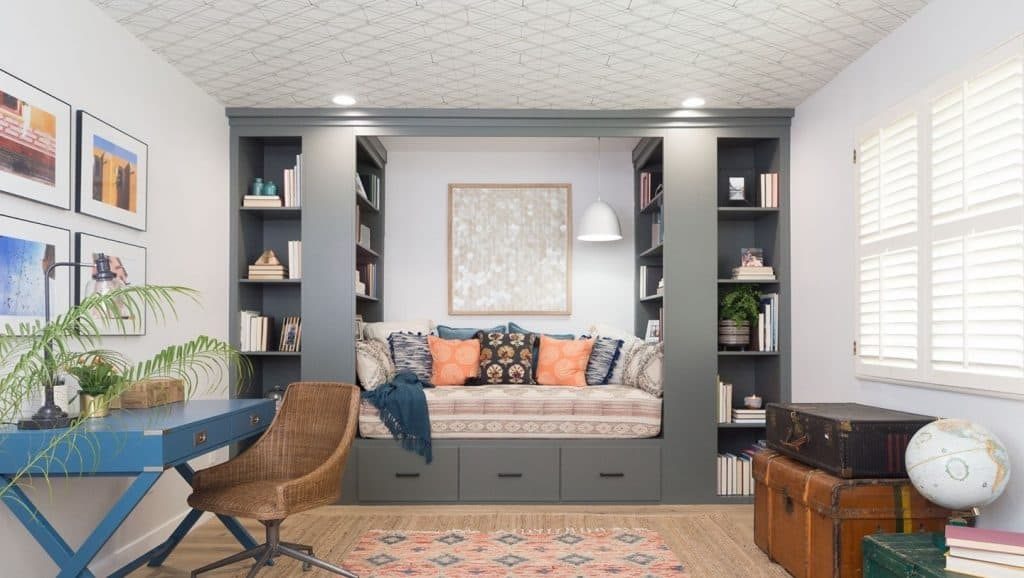 High contrast small living room with black accent wall, white sofa, and geometric rug.