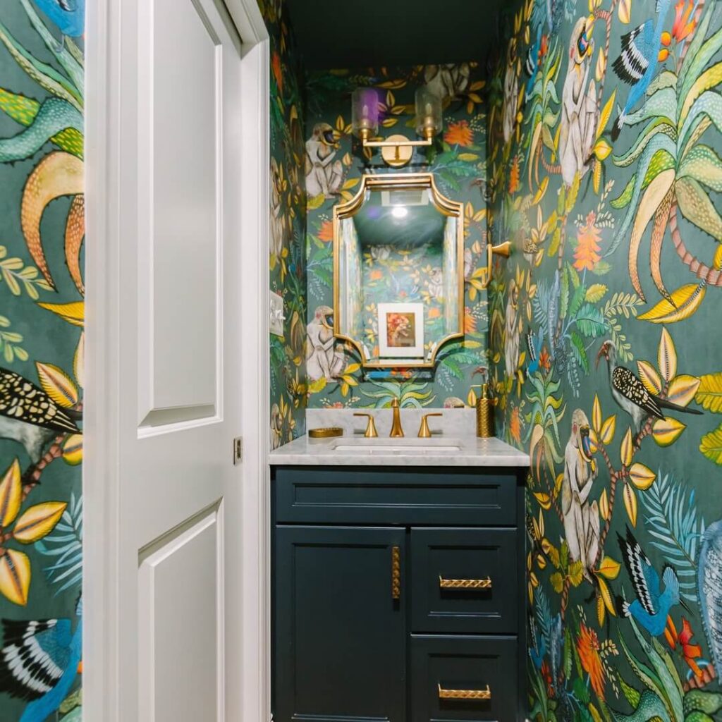 Half bathroom with jungle monkey wallpaper, teal vanity, white sink, playful décor.