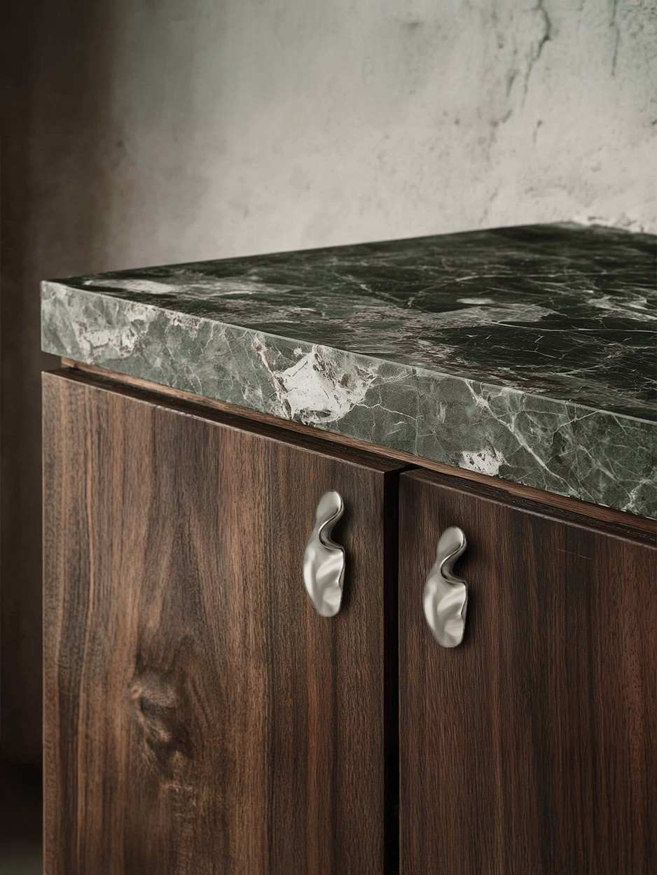 Rich dark wood kitchen cabinets with brushed nickel knobs in a warm home.
