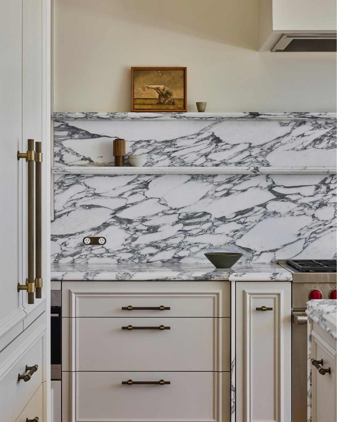Mid-tone gray cabinets with circular brass knobs in a clean, transitional kitchen.